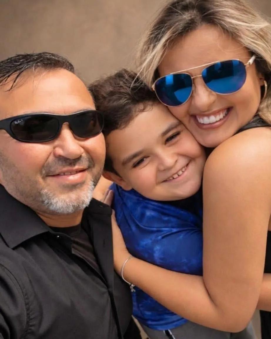 Regiane com o esposo Sandro e o filho Davi, abraçados e sorrindo